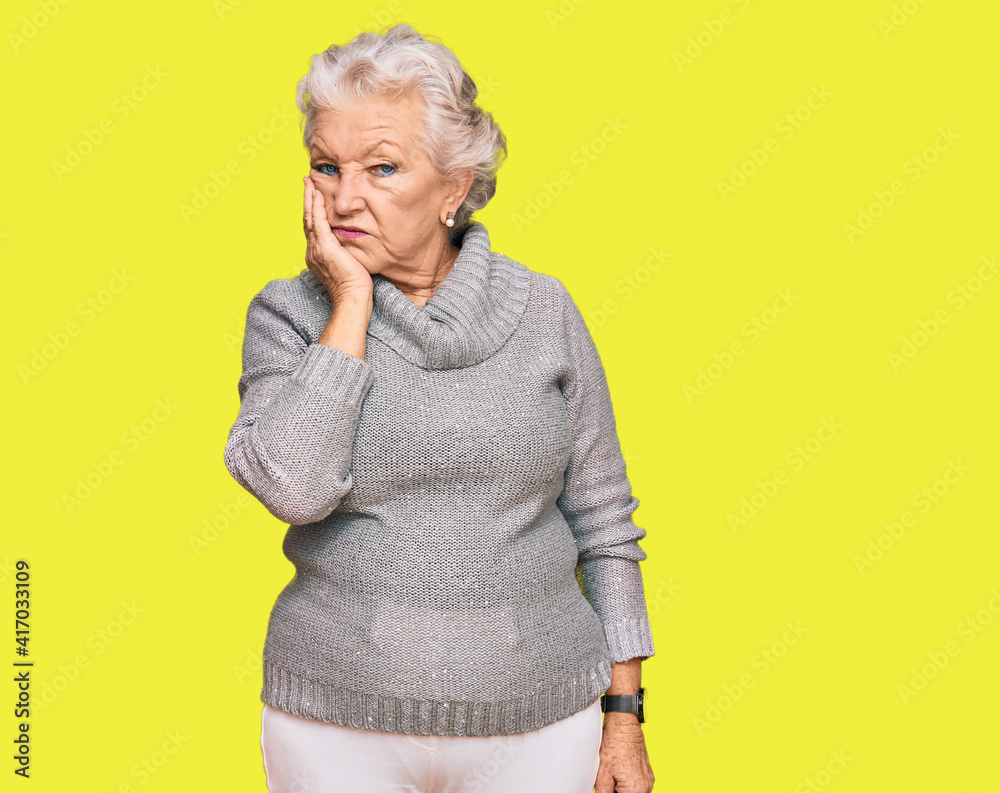 Senior grey-haired woman wearing casual winter sweater thinking looking tired and bored with depression problems with crossed arms. Senior grey-haired woman wearing casual winter sweater thinking looking tired and bored with depression problems with crossed arms.