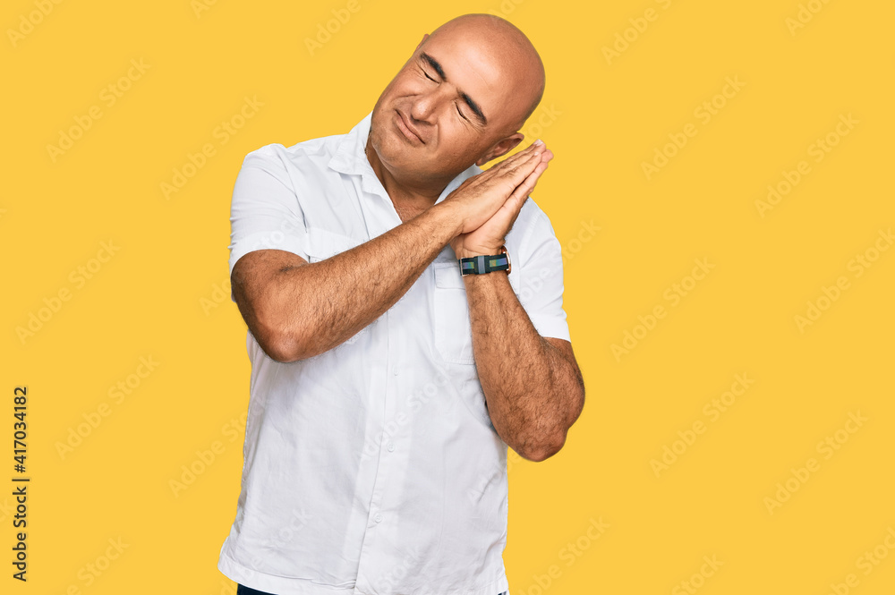 Mature middle east man with mustache wearing casual white shirt sleeping tired dreaming and posing with hands together while smiling with closed eyes. Mature middle east man with mustache wearing casual white shirt sleeping tired dreaming and posing with hands together while smiling with closed eyes.