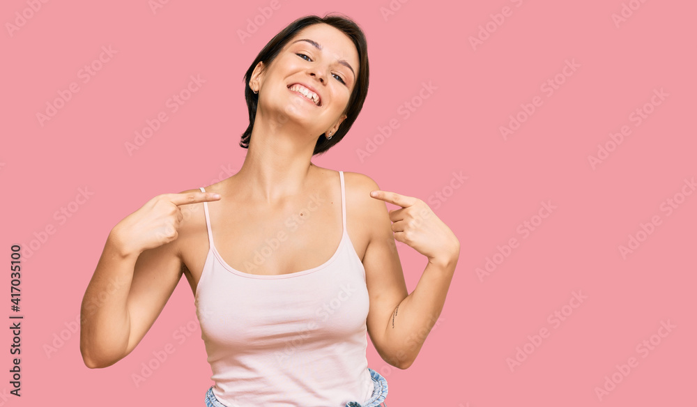Young brunette woman with short hair wearing casual summer clothes looking confident with smile on face, pointing oneself with fingers proud and happy. Young brunette woman with short hair wearing casual summer clothes looking confident with smile on face, pointing oneself with fingers proud and happy.