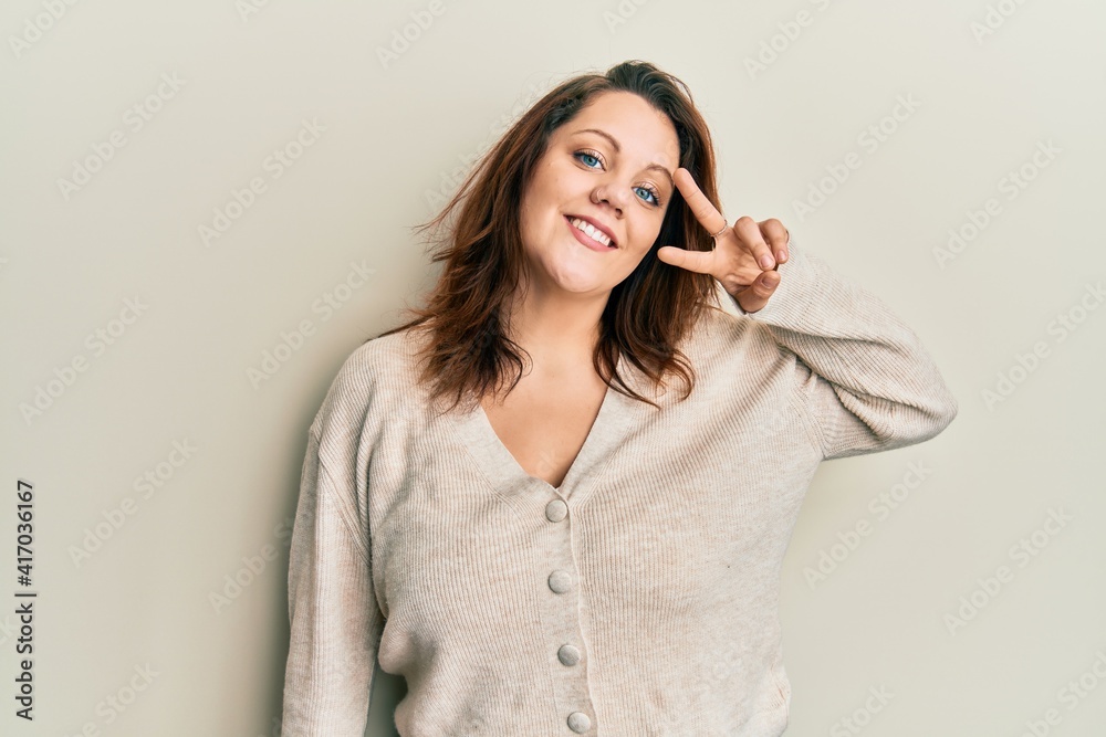 Young caucasian woman wearing casual clothes doing peace symbol with fingers over face, smiling cheerful showing victory Young caucasian woman wearing casual clothes doing peace symbol with fingers over face, smiling cheerful showing victory