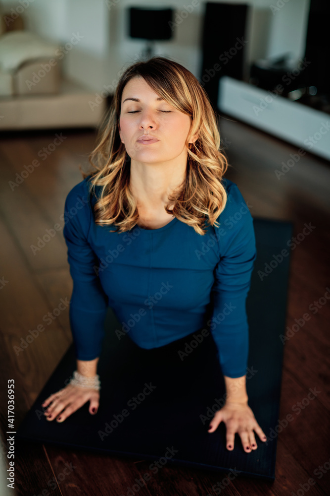 Woman practicing yoga at home with video tutorial. Woman practicing yoga at home with video tutorial.