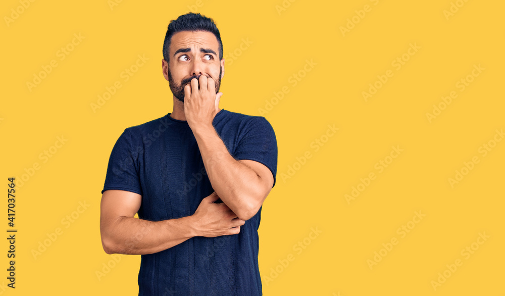 Young hispanic man wearing casual clothes looking stressed and nervous with hands on mouth biting nails. anxiety problem.