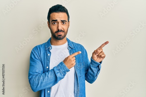 Young hispanic man pointing with fingers to himself skeptic and nervous  frowning upset because of problem. negative person.