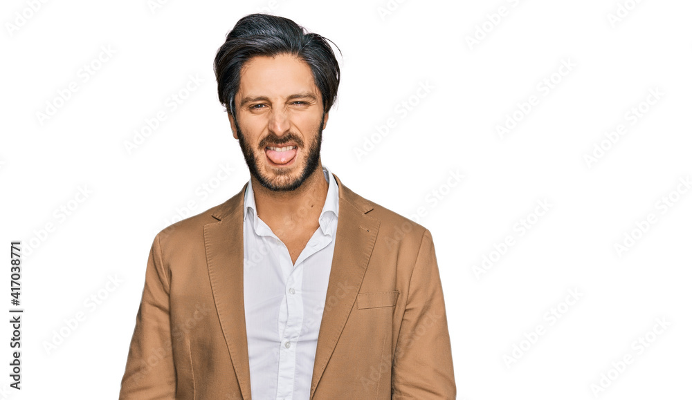 Young hispanic man wearing business clothes sticking tongue out happy with funny expression. emotion concept. Young hispanic man wearing business clothes sticking tongue out happy with funny expression. emotion concept.