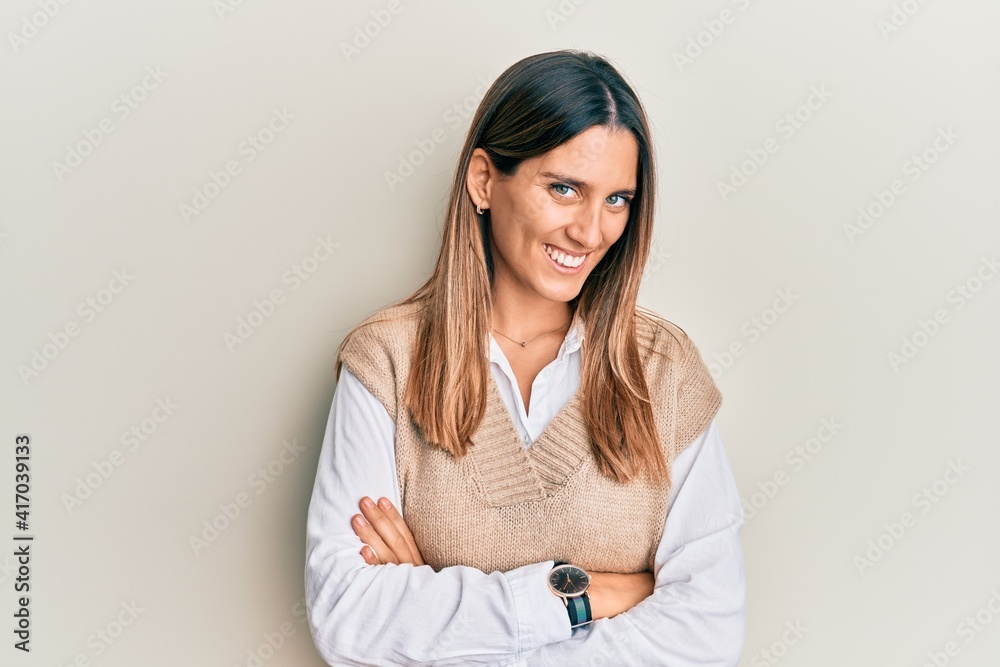 Brunette young woman wearing casual clothes happy face smiling with crossed arms looking at the camera. positive person. Brunette young woman wearing casual clothes happy face smiling with crossed arms looking at the camera. positive person.