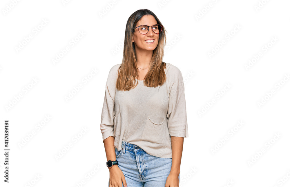 Young woman wearing casual clothes and glasses looking away to side with smile on face, natural expression. laughing confident. Young woman wearing casual clothes and glasses looking away to side with smile on face, natural expression. laughing confident.