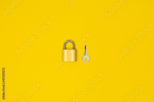 Key and padlock, lock on yellow background
