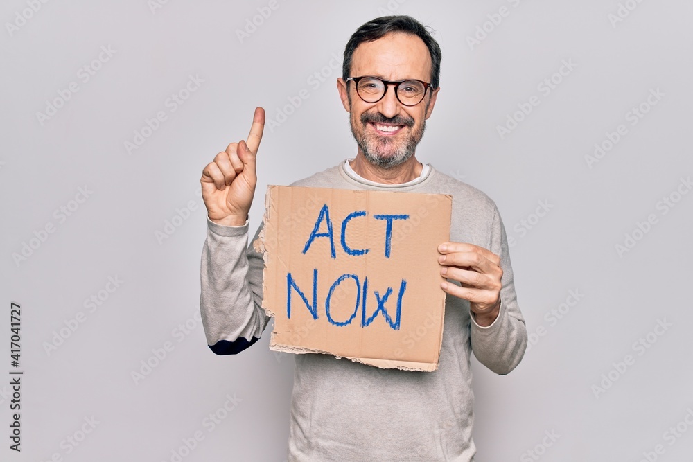 Middle age handsome man asking for rights holding banner with act now message smiling with an idea or question pointing finger with happy face, number one Middle age handsome man asking for rights holding banner with act now message smiling with an idea or question pointing finger with happy face, number one