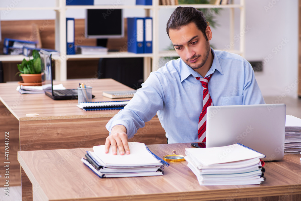 Fototapeta premium Young male employee unhappy with excessive work