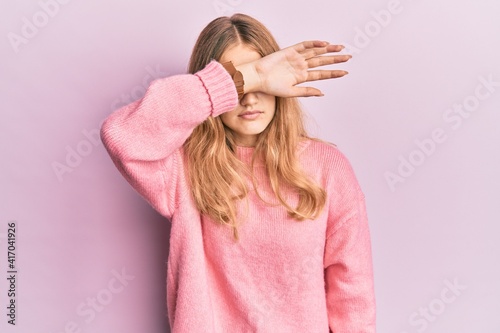 Beautiful young caucasian girl wearing casual clothes covering eyes with arm, looking serious and sad. sightless, hiding and rejection concept