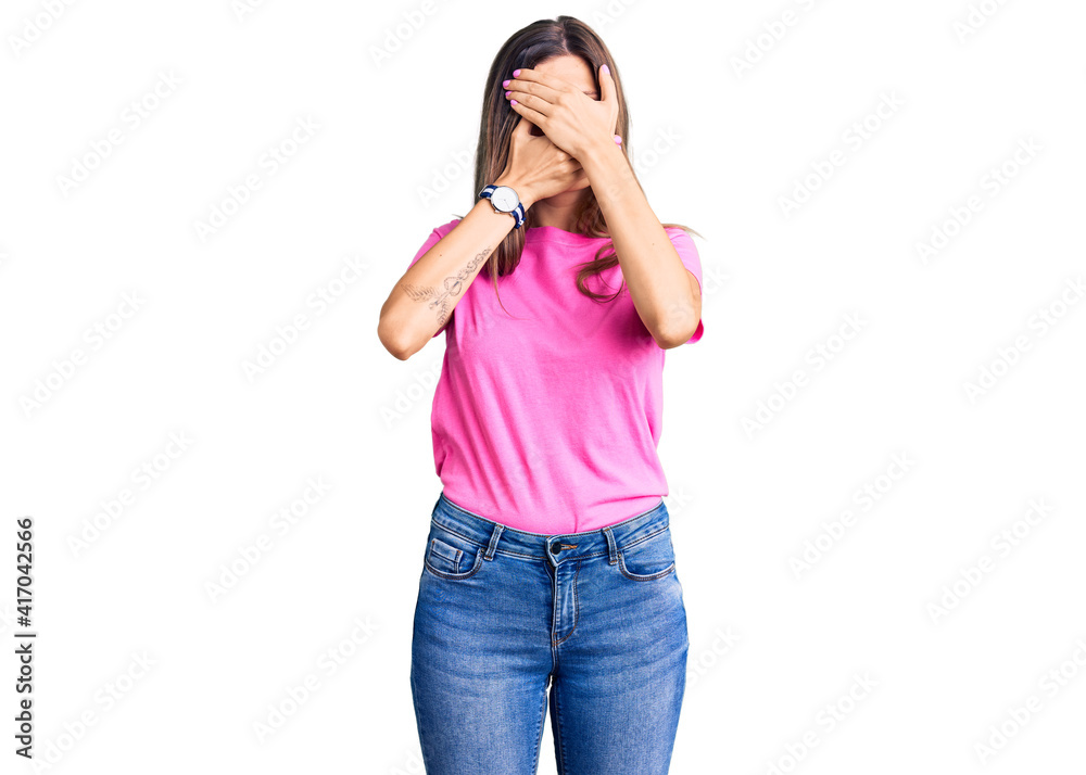 Beautiful caucasian woman wearing casual clothes covering eyes and mouth with hands, surprised and shocked. hiding emotion Beautiful caucasian woman wearing casual clothes covering eyes and mouth with hands, surprised and shocked. hiding emotion
