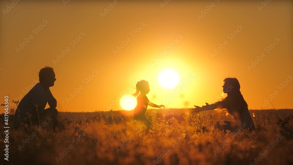 Silhouette of a daddy circling a small child in flight at sunset. Father's day. A daughter with a parent is playing a game against the background of the sky. Kid soar in the air at dawn. Teamwork