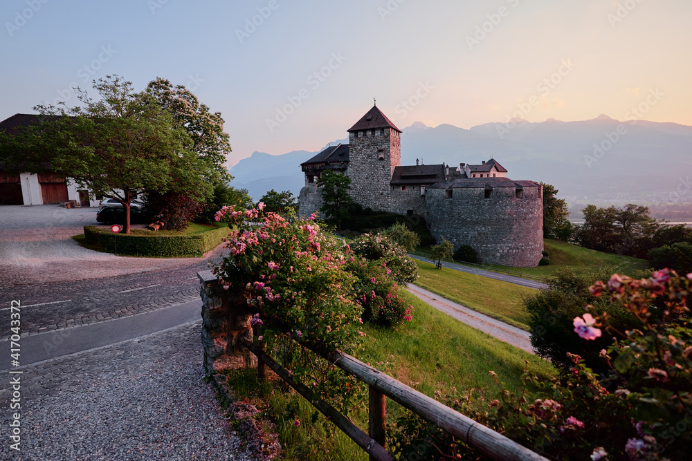 Obraz premium Vaduz Castle, the official residence of the Prince of Liechtenstein, with Alps mountains in background on sunset.