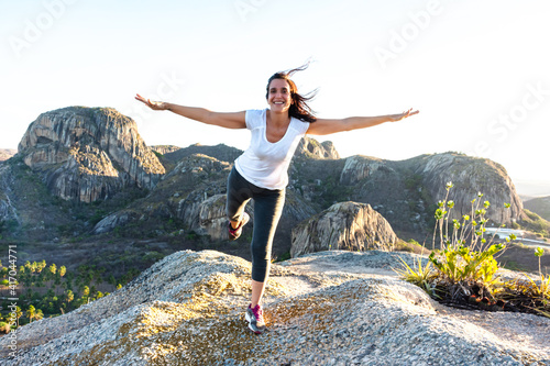 Mulher feliz de braços abertos em cima da montanha rochosa photo