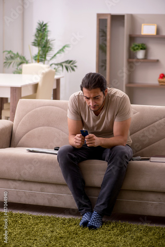 Young man ordering goods by credit card at home