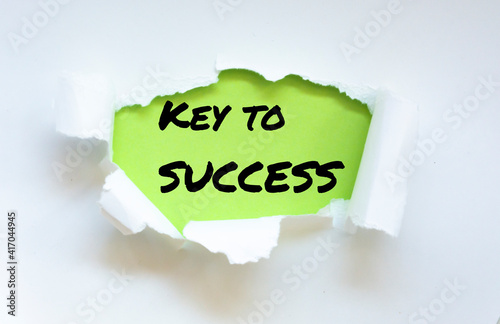 Text appearing behind torn white envelop - Key to success