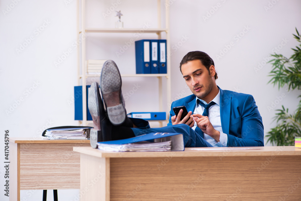 Young male employee and too many work in the office Young male employee and too many work in the office
