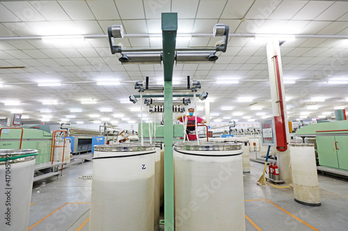 The female worker is busy on the production line in a spinning factory.