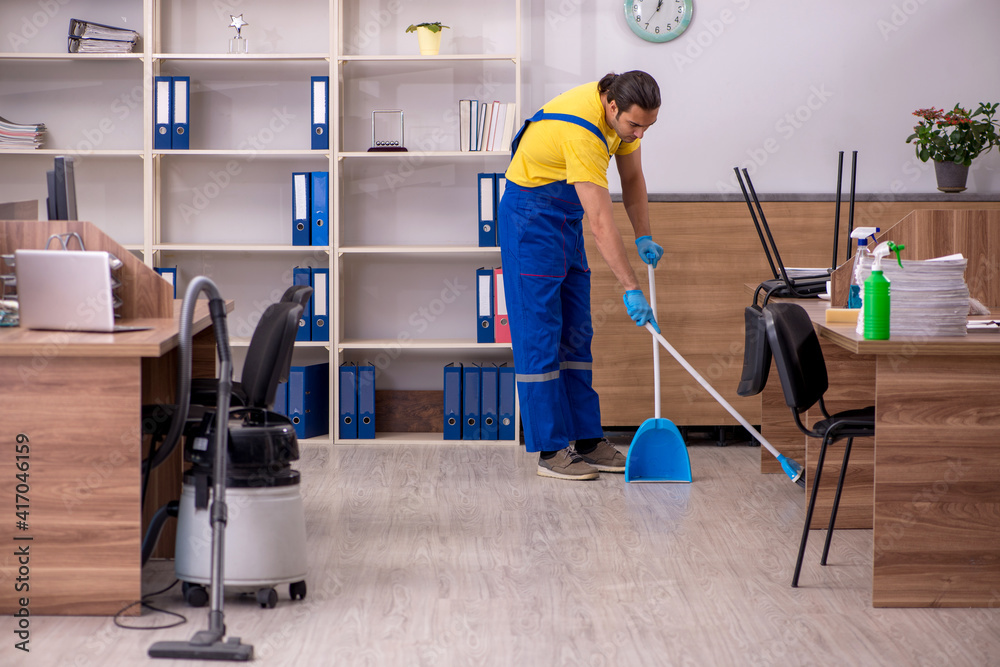 Young male contractor cleaning the office Young male contractor cleaning the office