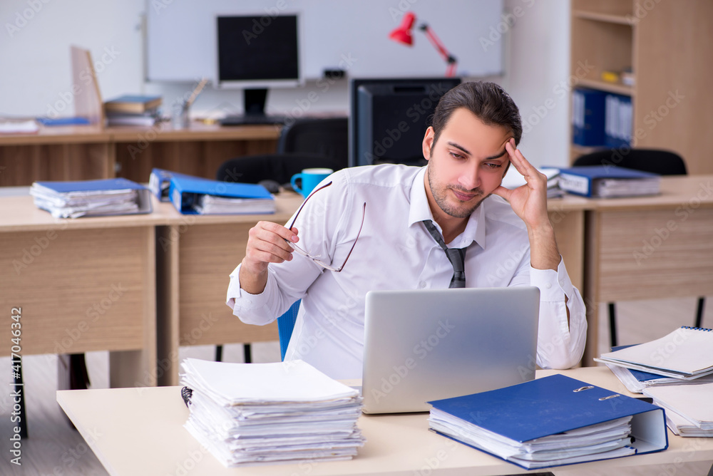 Young male employee unhappy with excessive work Young male employee unhappy with excessive work