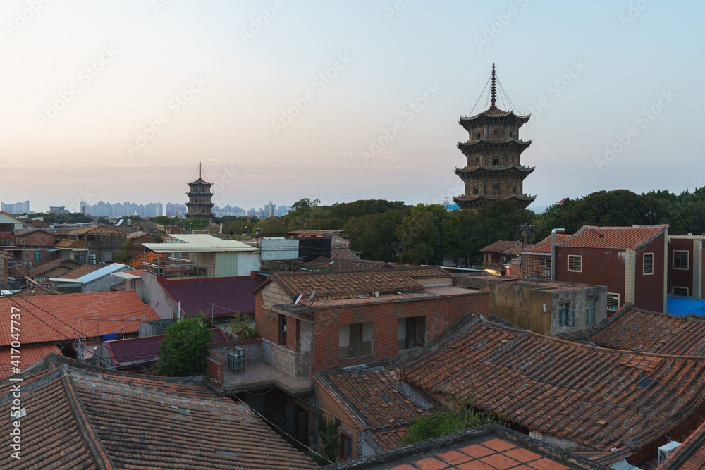 Sunset landscapes of east and west towers of Kaiyuan Temple, the largest buddhist temple in Fujian Province, with old buildings in Quanzhou, China