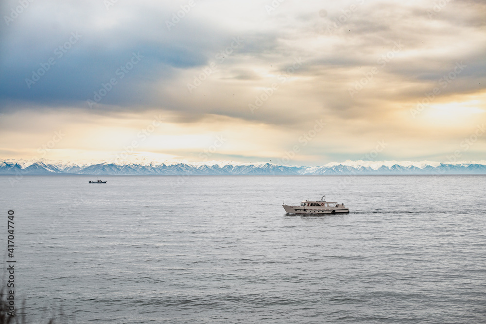 the boat sails on lake Baikal / mountains in the distance the boat sails on lake Baikal / mountains in the distance