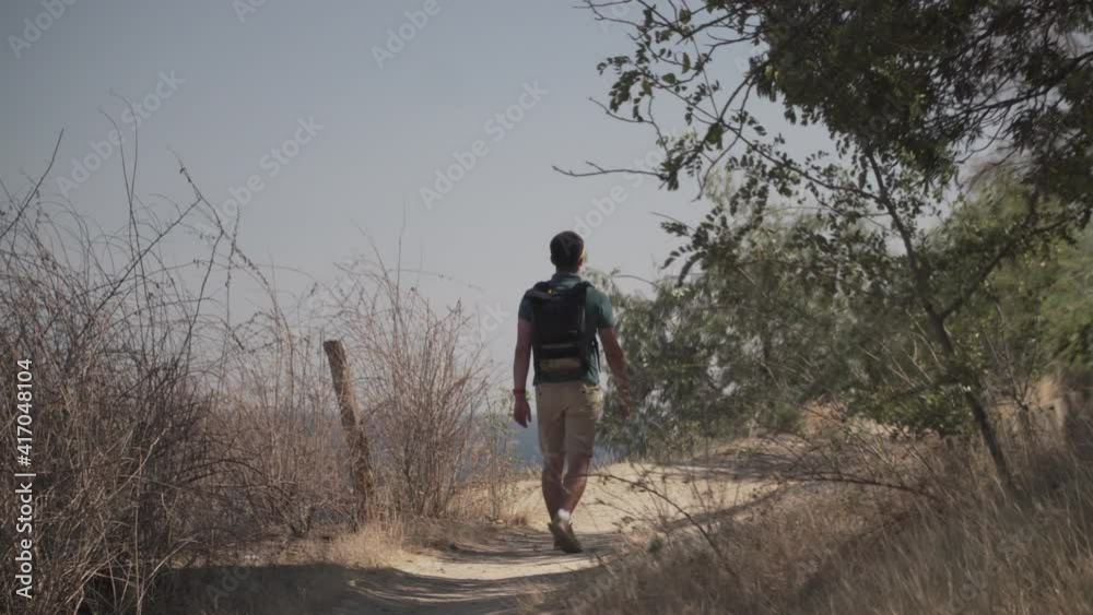 Caucasian male tourist delighting sea view in sunny summer weather during haikin on mountain trail. Hiking on Lycian way. Traveler with backpack stands on cliff. Adventure, travel people concept Caucasian male tourist delighting sea view in sunny summer weather during haikin on mountain trail. Hiking on Lycian way. Traveler with backpack stands on cliff. Adventure, travel people concept