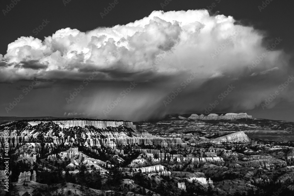dramatic landscape photo of Bryce Canyon.gigantic  cumulonimbus desert storm cloud passing through the hoodoos of the Bryce Canyon National Park just right after sunset.