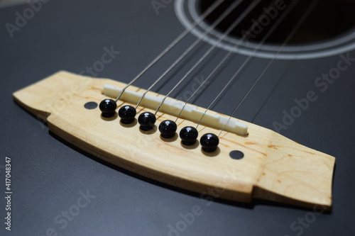 Close up part of black accoustic guitar