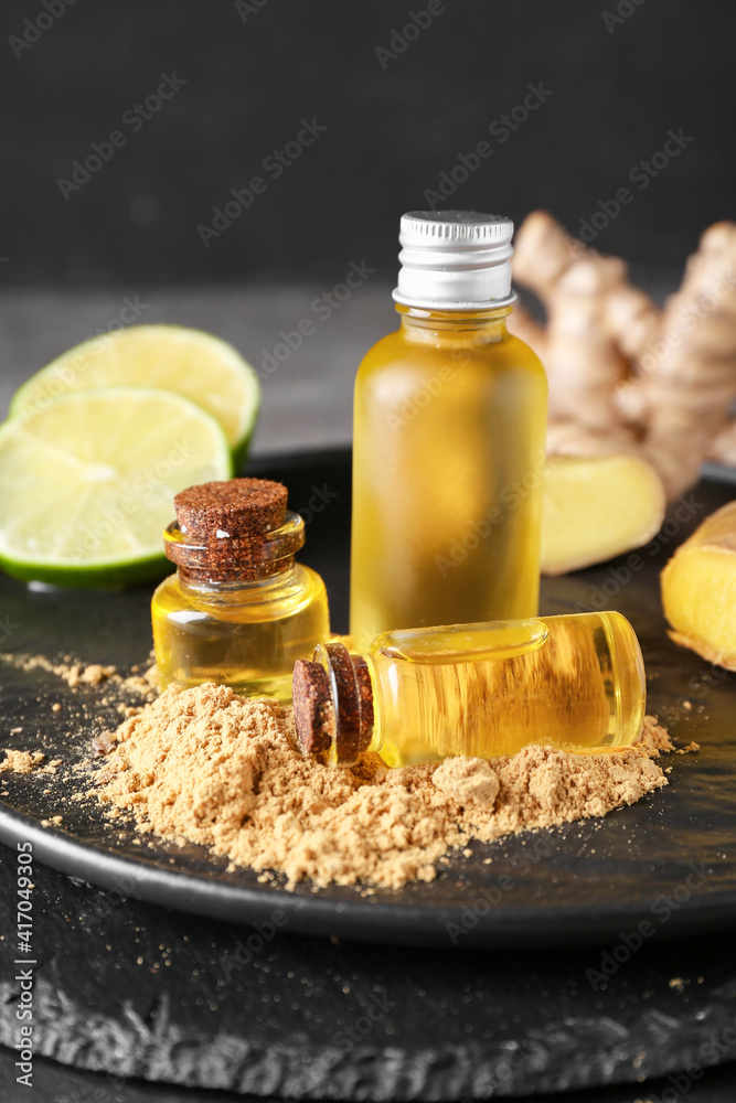 Bottles with ginger essential oil on dark table Bottles with ginger essential oil on dark table