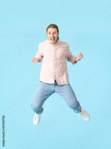 Jumping young man against c...