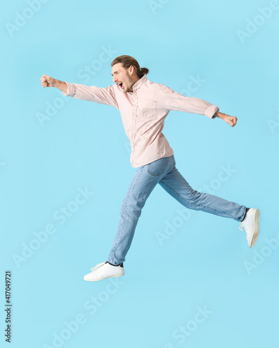 Jumping young man against c...