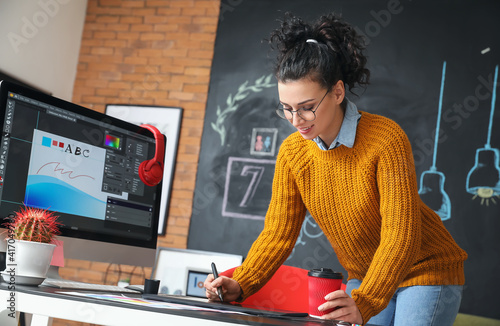 Young female designer worki...