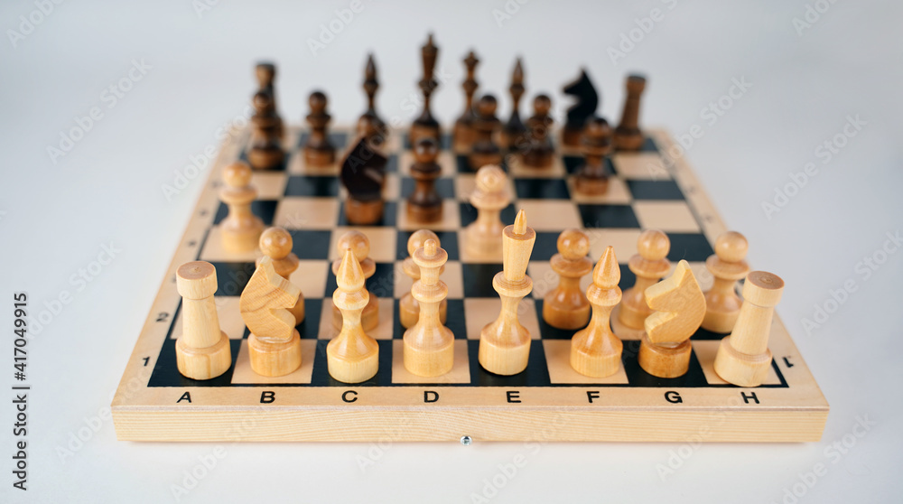 Close-up of chess on a gray background. Wooden chess pieces. Concept: the Board game and the intellectual activities Close-up of chess on a gray background. Wooden chess pieces. Concept: the Board game and the intellectual activities