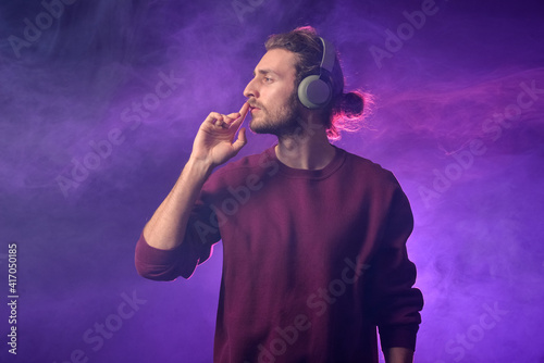 Handsome young man listenin...