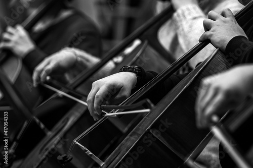 Hands of a musician playing the cello in an orchestra in black and white