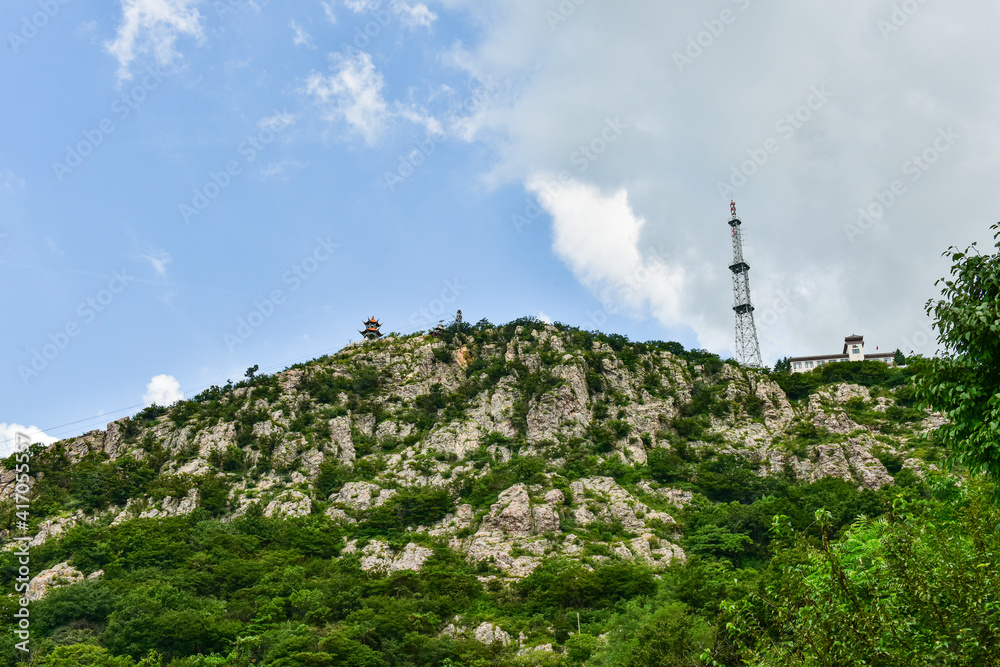 Fototapeta premium Peaks and forest landscape in the background of blue sky and white clouds. Photographed in Dagushan, Dandong, Liaoning, China