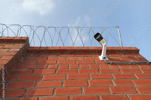 CCTV camera on a brick wall. Secured territory.