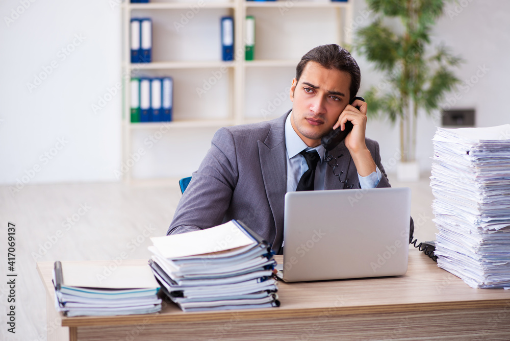 Young male employee unhappy with excessive work Young male employee unhappy with excessive work