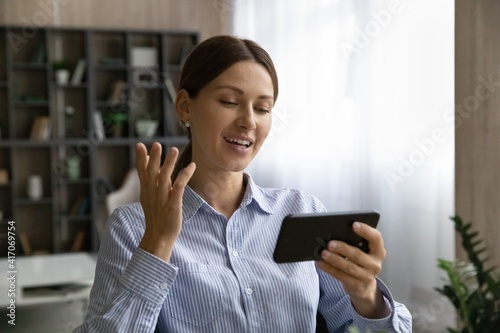 Young Caucasian woman use cellphone talk speak on video call with client or colleague. Millennial female have webcam online digital conference on modern smartphone gadget. Virtual event concept.