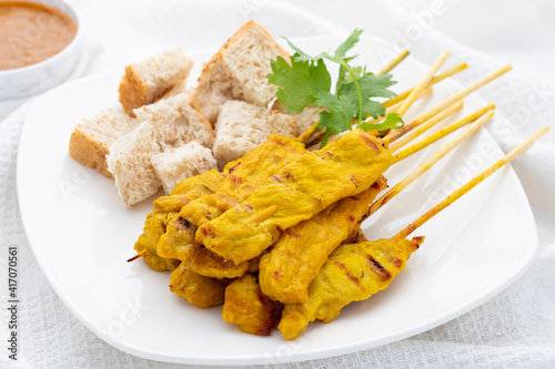 Obraz na plátně Pork satay or moo satay in Thai served with peanut satay sauce and whole wheat bread