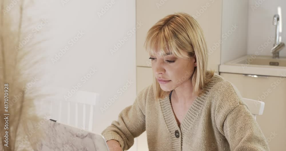 
Online work, home office. A woman works at the computer at home in the evening