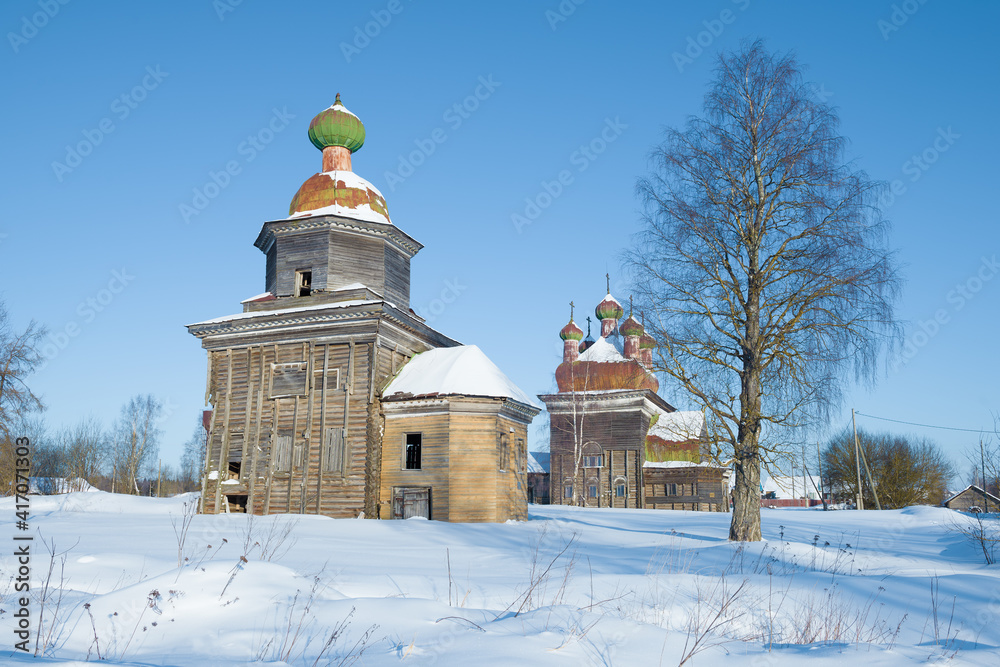 Ancient wooden churches of Archangel Michael and the Presentation of the Lord on a sunny February day. Temple complex in Shelokhovskaya. Arkhangelsk region, Russia