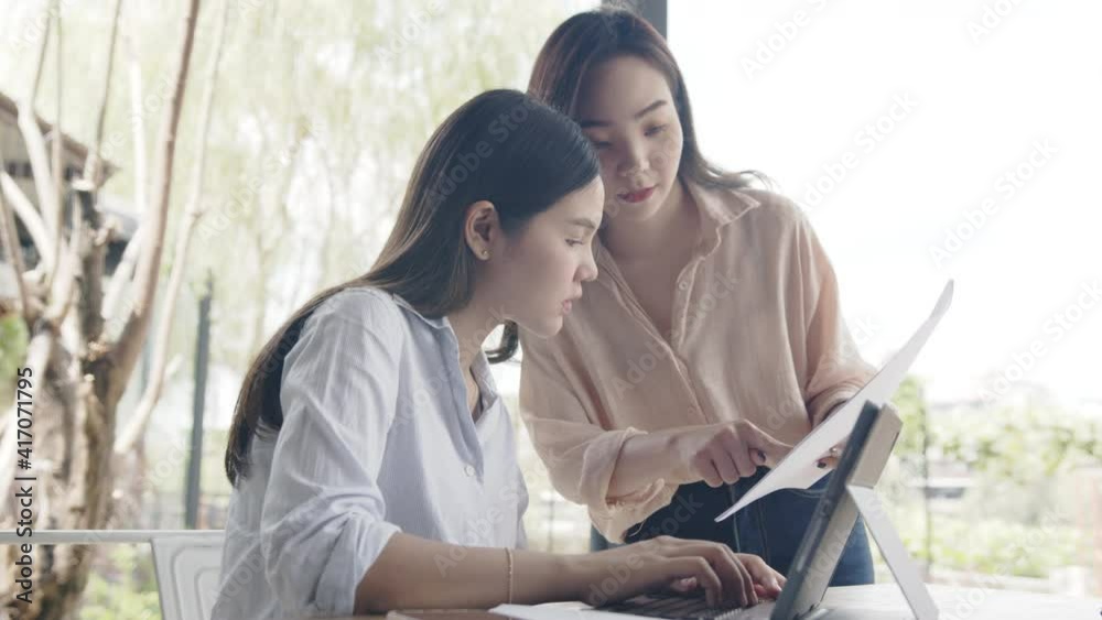 Two young Asian businesswoman discussing project meeting at coffee shop. Two young Asian businesswoman discussing project meeting at coffee shop.