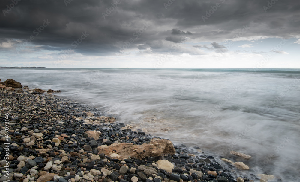Seawaves splashing to the coast with stones against stormy dramatic cloudy sky. Wintertime, Limassol cyprus Seawaves splashing to the coast with stones against stormy dramatic cloudy sky. Wintertime, Limassol cyprus