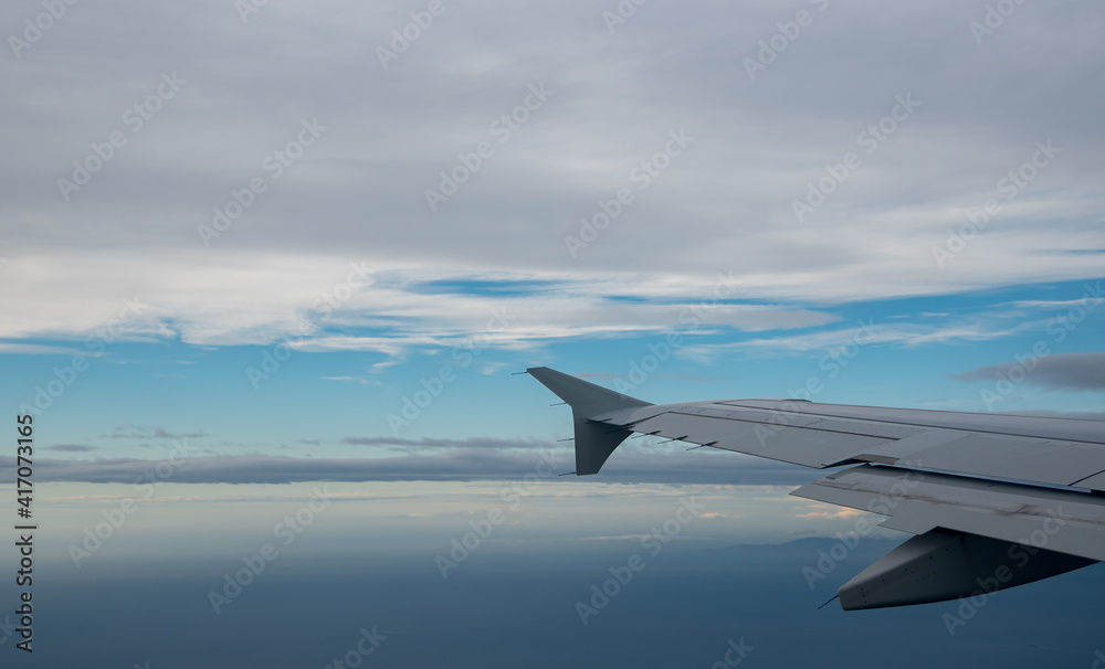 Fototapeta premium Plane wing in a flight and dramatic cloudscape white clouds over europe