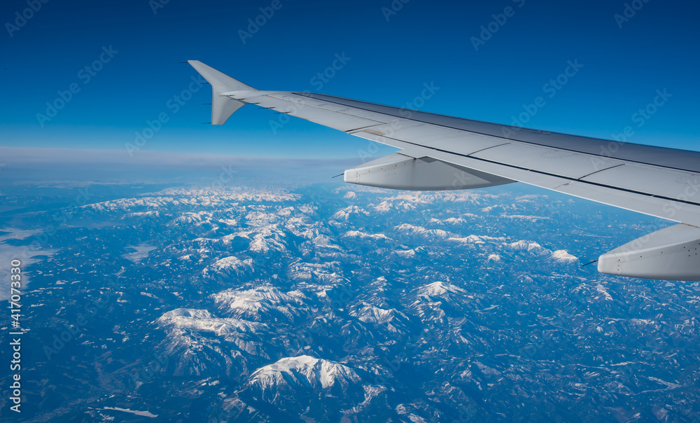 Obraz premium Plane wing in a flight and dramatic cloudscape white clouds over europe