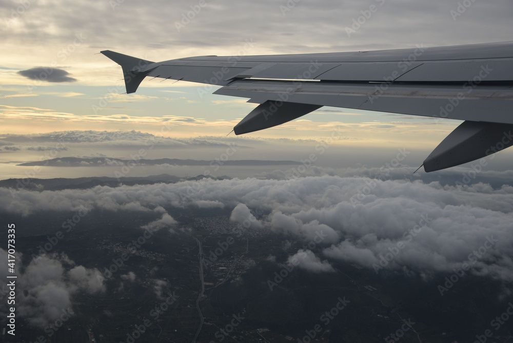 Plane wing in a flight and dramatic cloudscape white clouds over europe Plane wing in a flight and dramatic cloudscape white clouds over europe