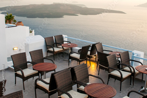 Roof garden cafe restaurant at the caldera in the Aegean sea at sunset. Santorini island Greece