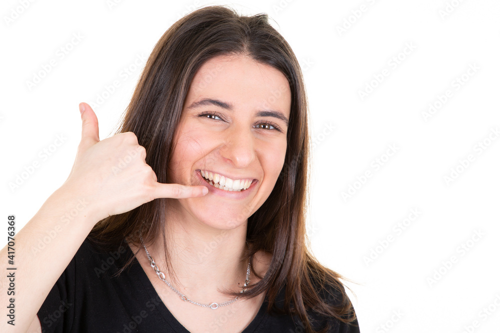 young pretty woman smiling showing gesture call me phone with fingers isolated on white background young pretty woman smiling showing gesture call me phone with fingers isolated on white background